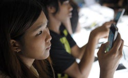 Potential customers trying various models of smartphones.